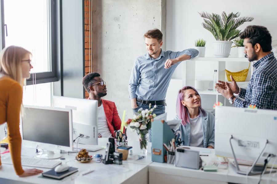 A team of colleagues in an office smiling at each other