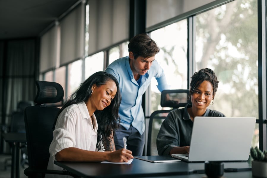 A smiling group of colleagues at a desk