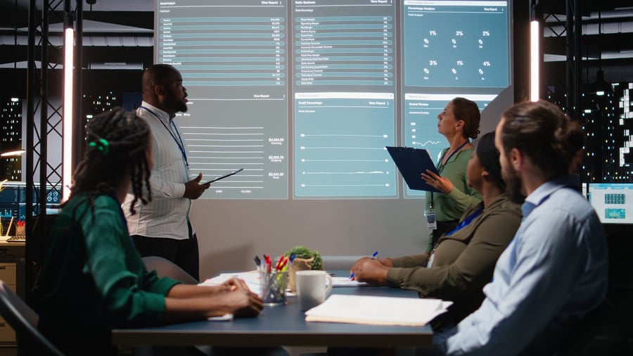 A business meeting where colleagues are looking at data on a screen