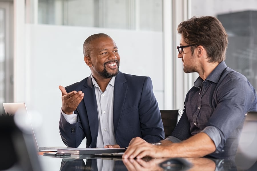 Two colleagues smiling at each other during a meeting in an office