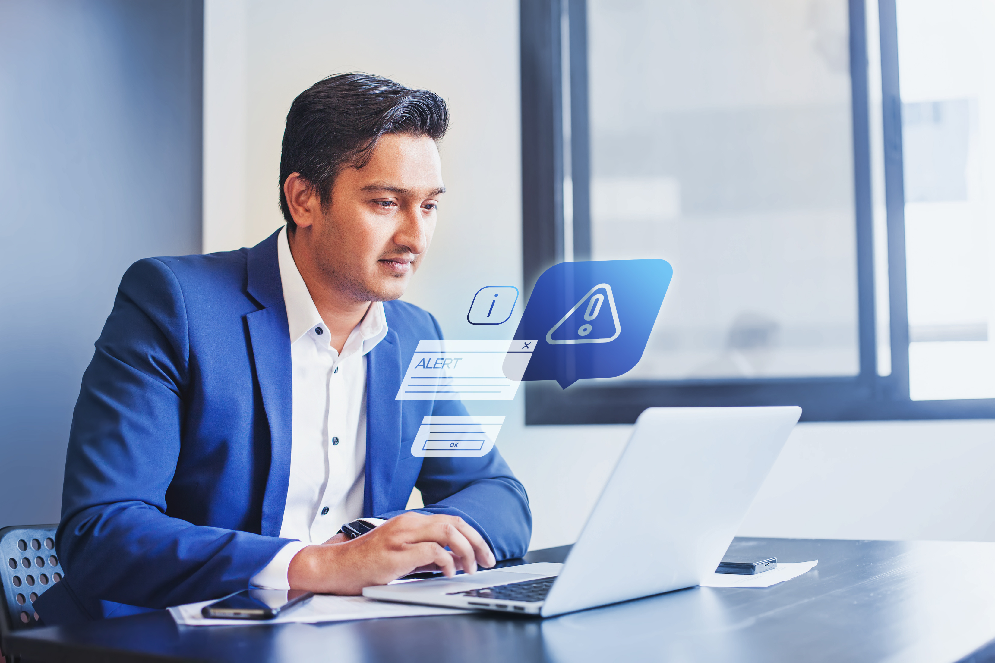 A man typing on a laptop with alert graphics coming up around him