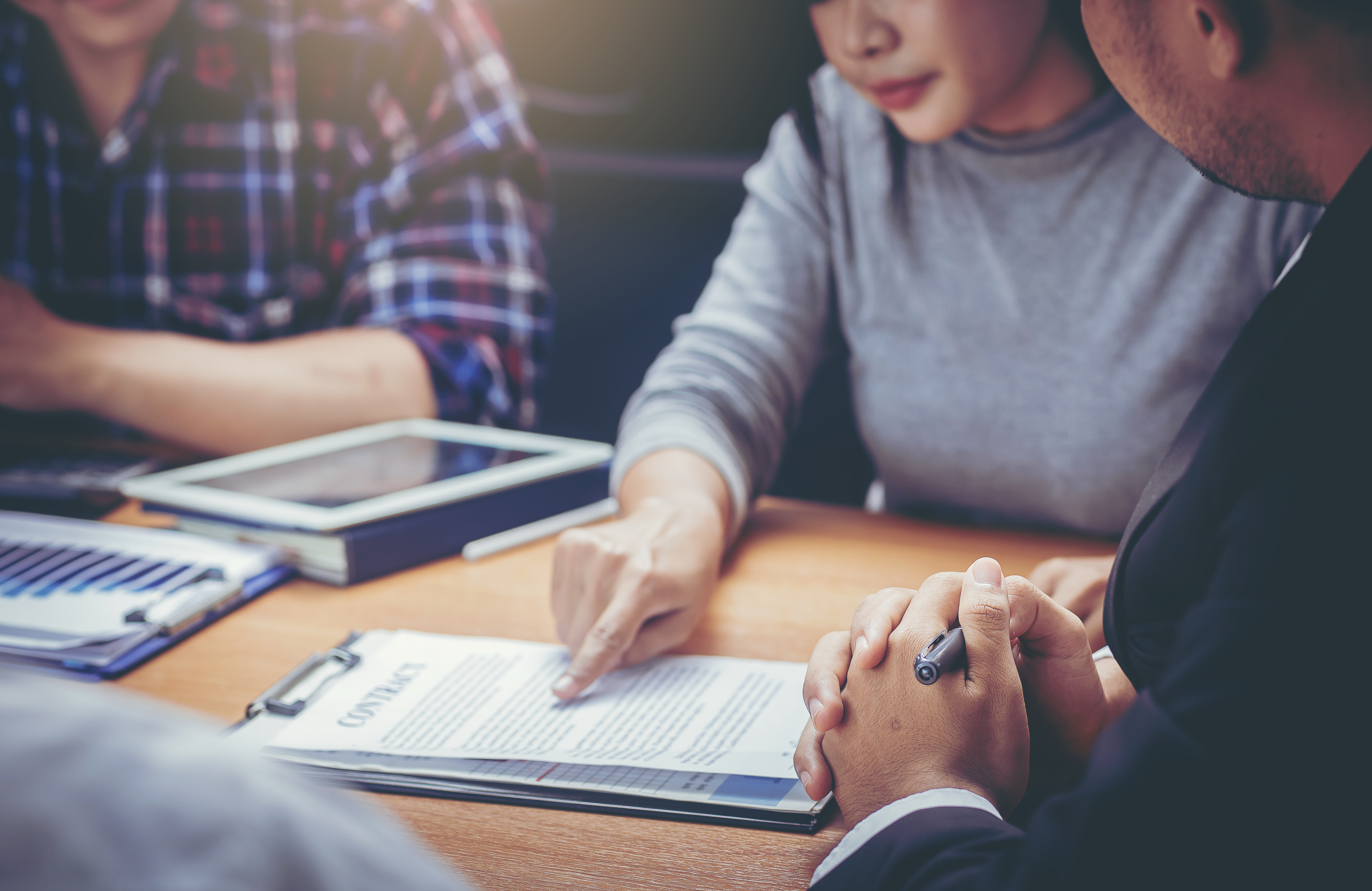 A group of people going over a contract together around a table