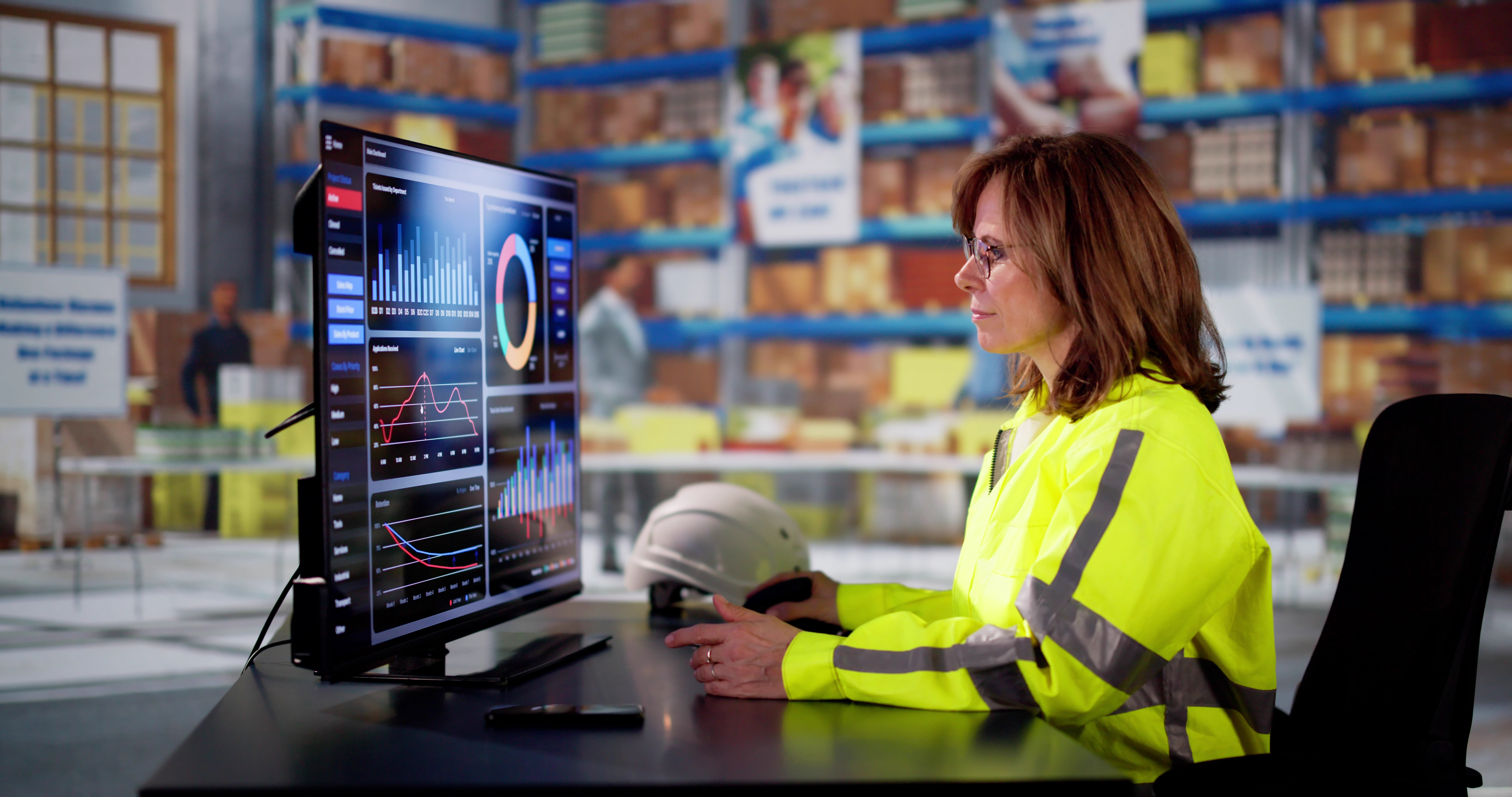 A woman in hi-vis types at a computer